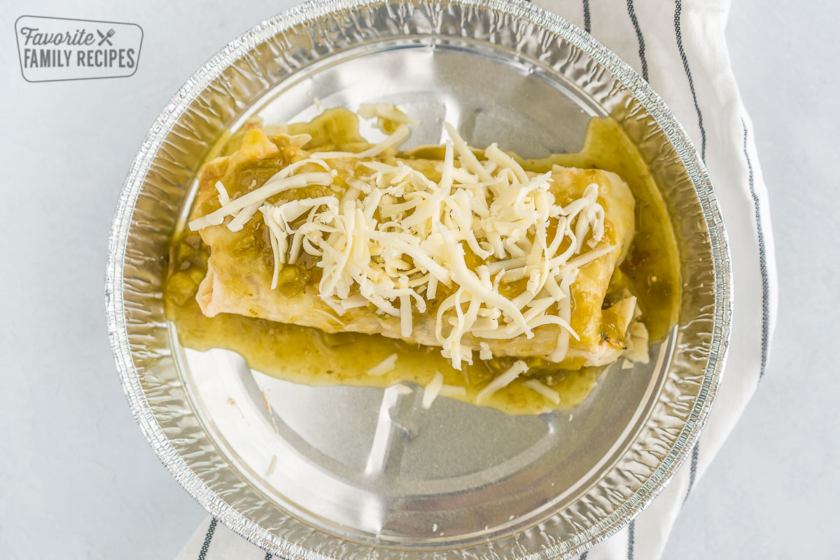 A burrito topped with enchilada sauce and cheese