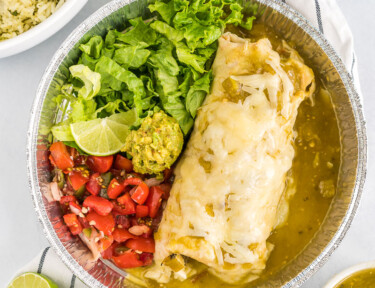 A homemade cafe rio sweet pork burrito with lettuce and pico de gallo