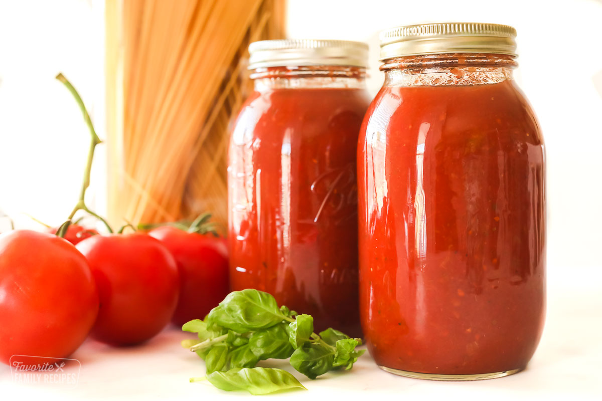 Large jars of homemade spaghetti sauce that have been canned.