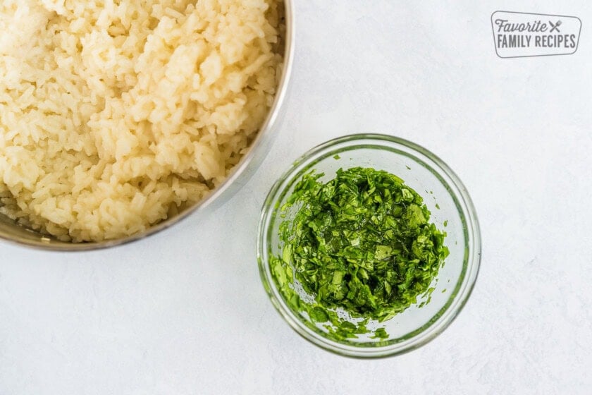 A large pot of cooked white rice and a small bowl of cilantro lime mixture