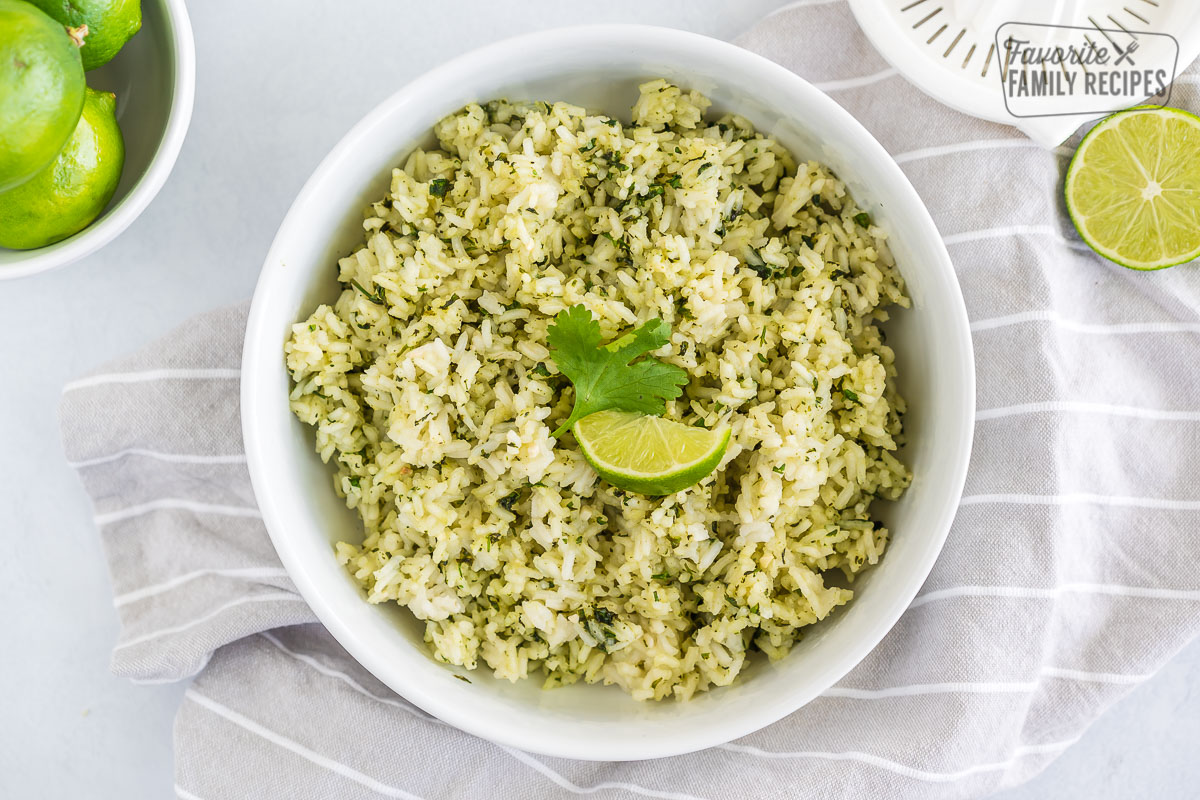 A bowl of cilantro lime rice topped with a lime wedge and a cilantro leaf