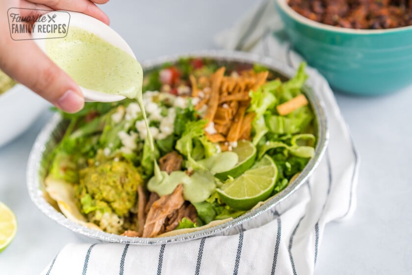 Dressing being poured over a salad