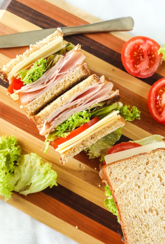 Turkey sandwich on a cutting board cut in half and facing up