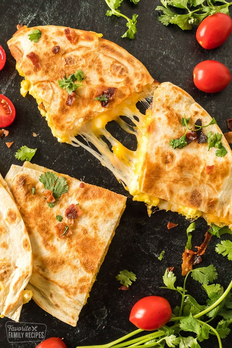 Quesadillas that have been grilled on a skillet until golden brown. They are filled with cheese, scrambled eggs, and bacon.