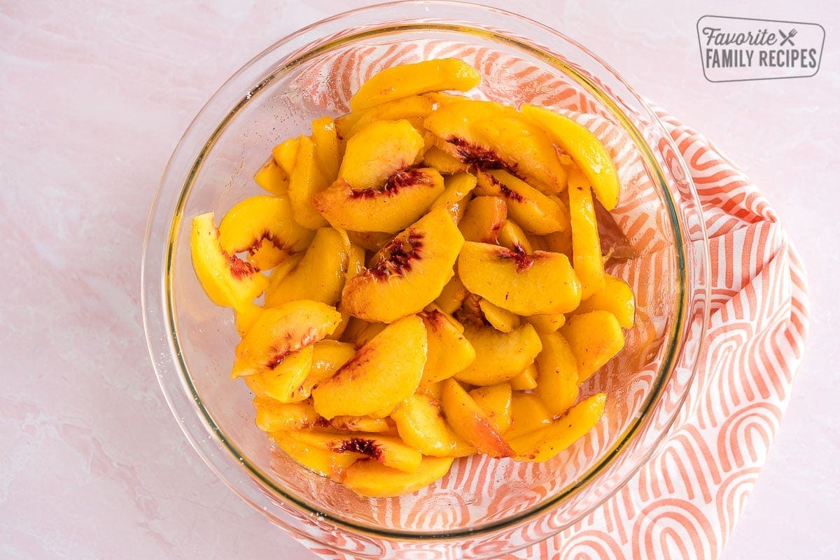 Sliced peaches in a glass bowl. 