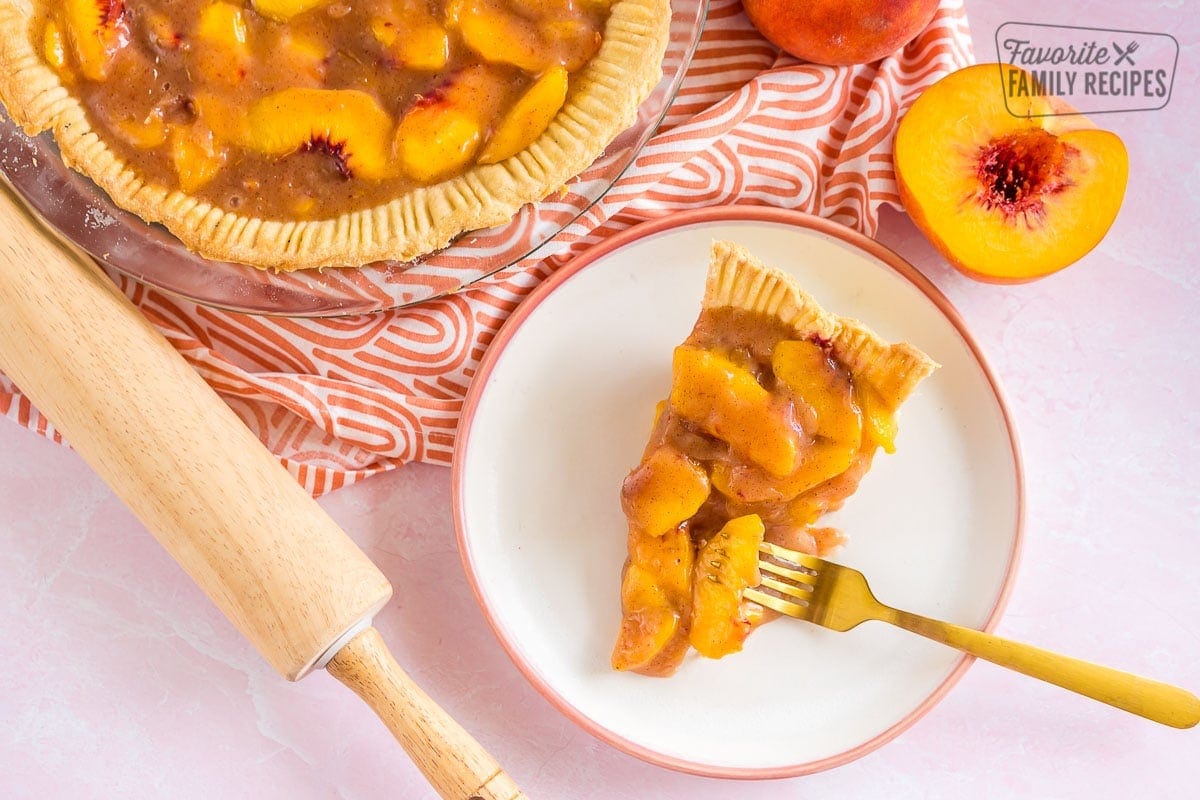 A slice of fresh peach pie on a plate