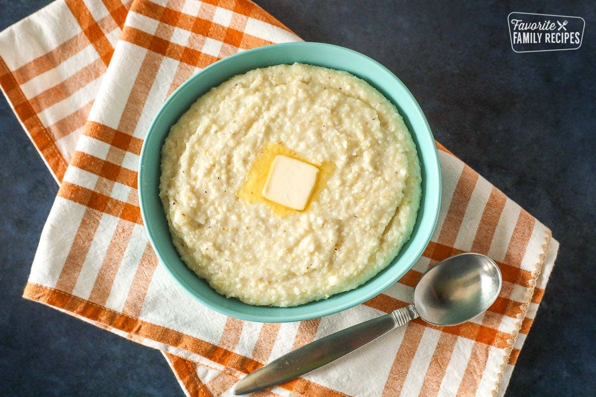 Bowl of Grits with butter on top and a spoon