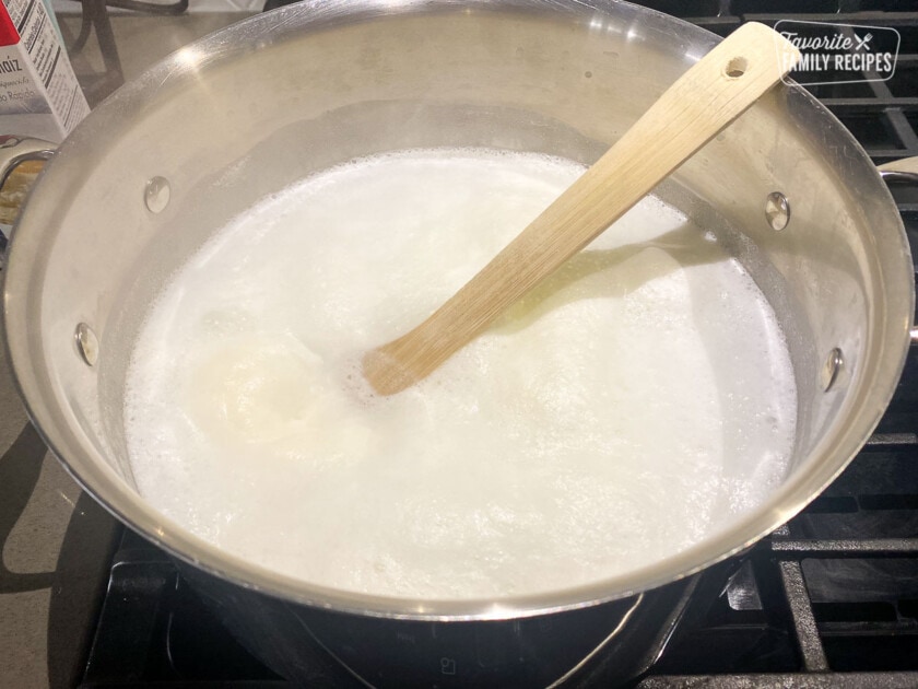 Bringing water, milk, butter, and salt to a boil in a pan