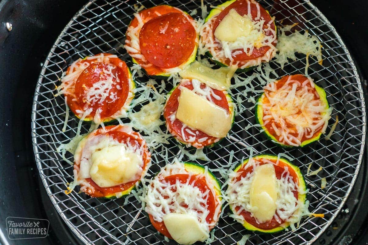 Pizza zucchini bites fully cooked sitting on an air fryer rack
