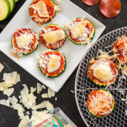 Slices of zucchini topped with pizza sauce, cheese, and pepperoni that has been cooked in the air fryer