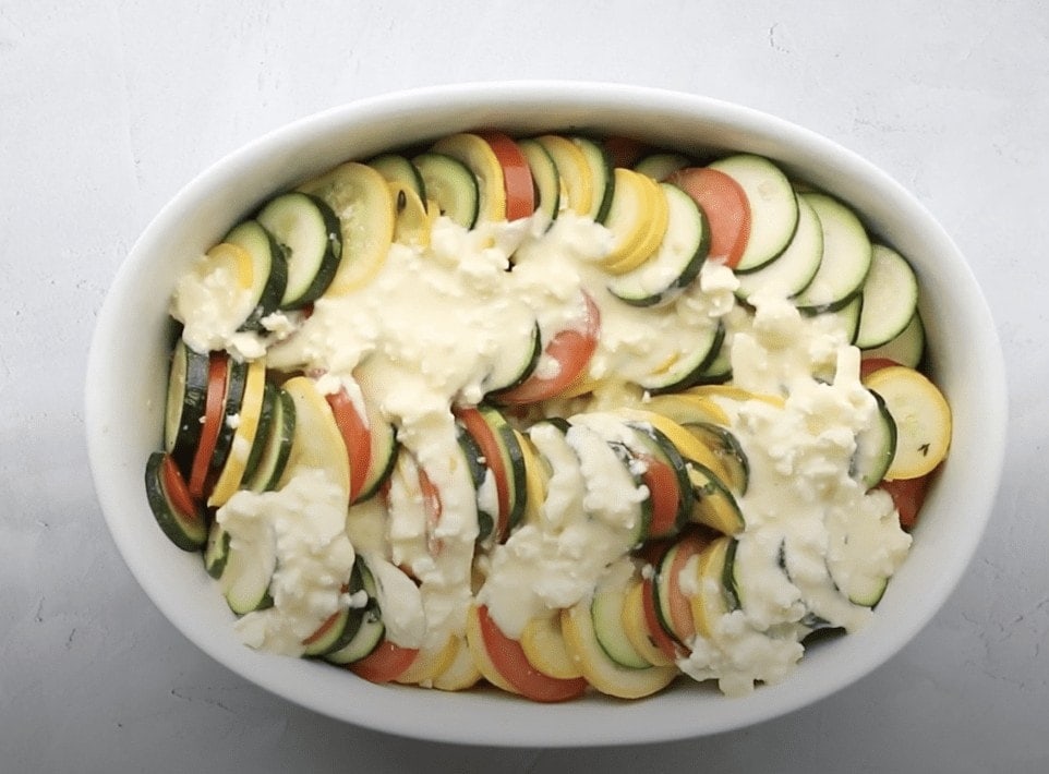 A casserole dish with vegetables with an egg mixture poured over the top