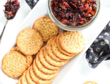 Top view of a jar of bacon jam with crackers