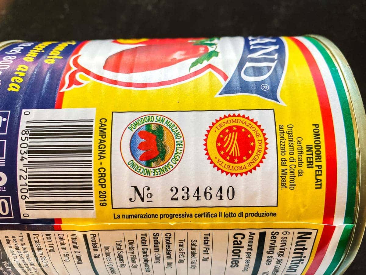 A close up of a label from a can of tomatoes from Italy showing the DOP seal and the official region seal and serial number