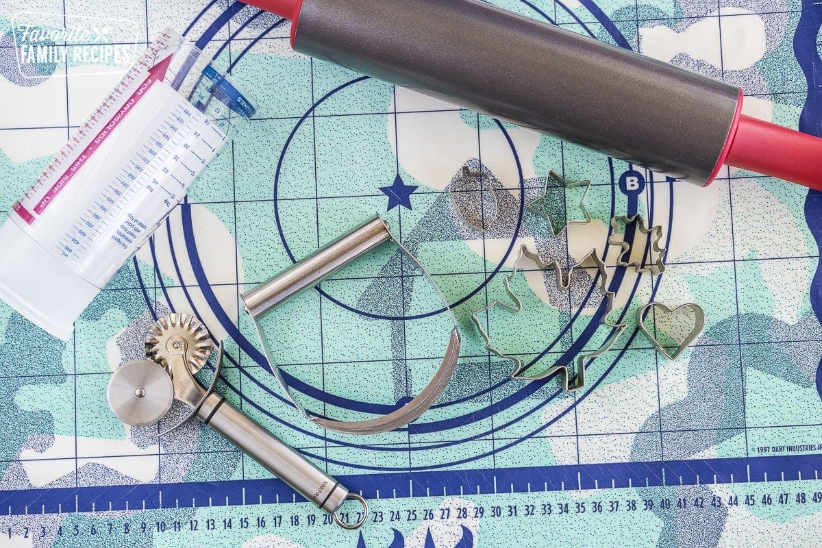 A pastry mat with a variety of pastry tools and cookie cutters