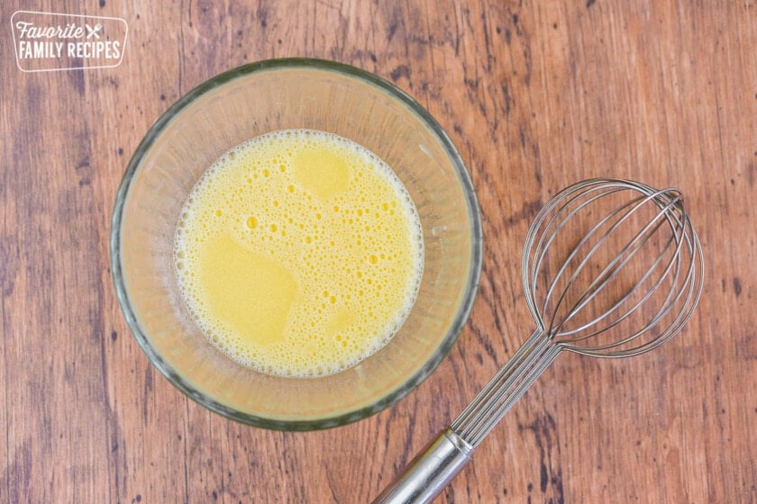 Egg and vinegar mixed in a small bowl with a whisk