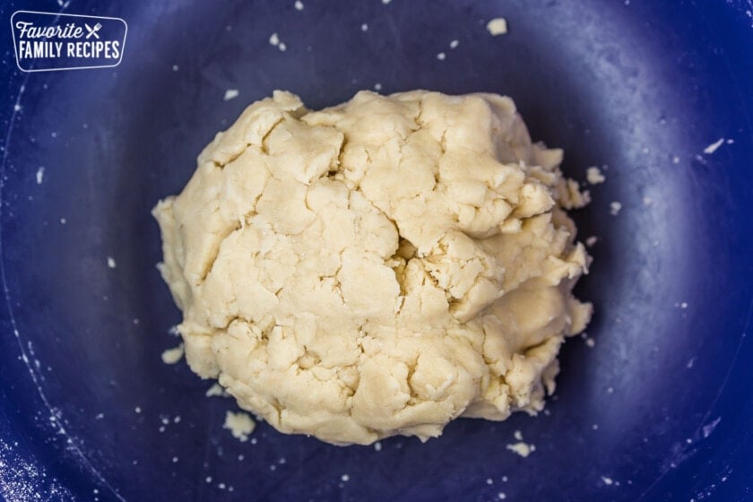 A ball of pie crust dough in a bowl.