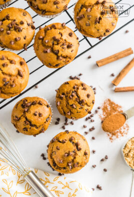 Pumpkin chocolate chip muffins on a cooling rack with some on the counter