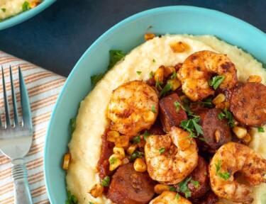 Shrimp and grits in a bowl with a napkin and fork on the side
