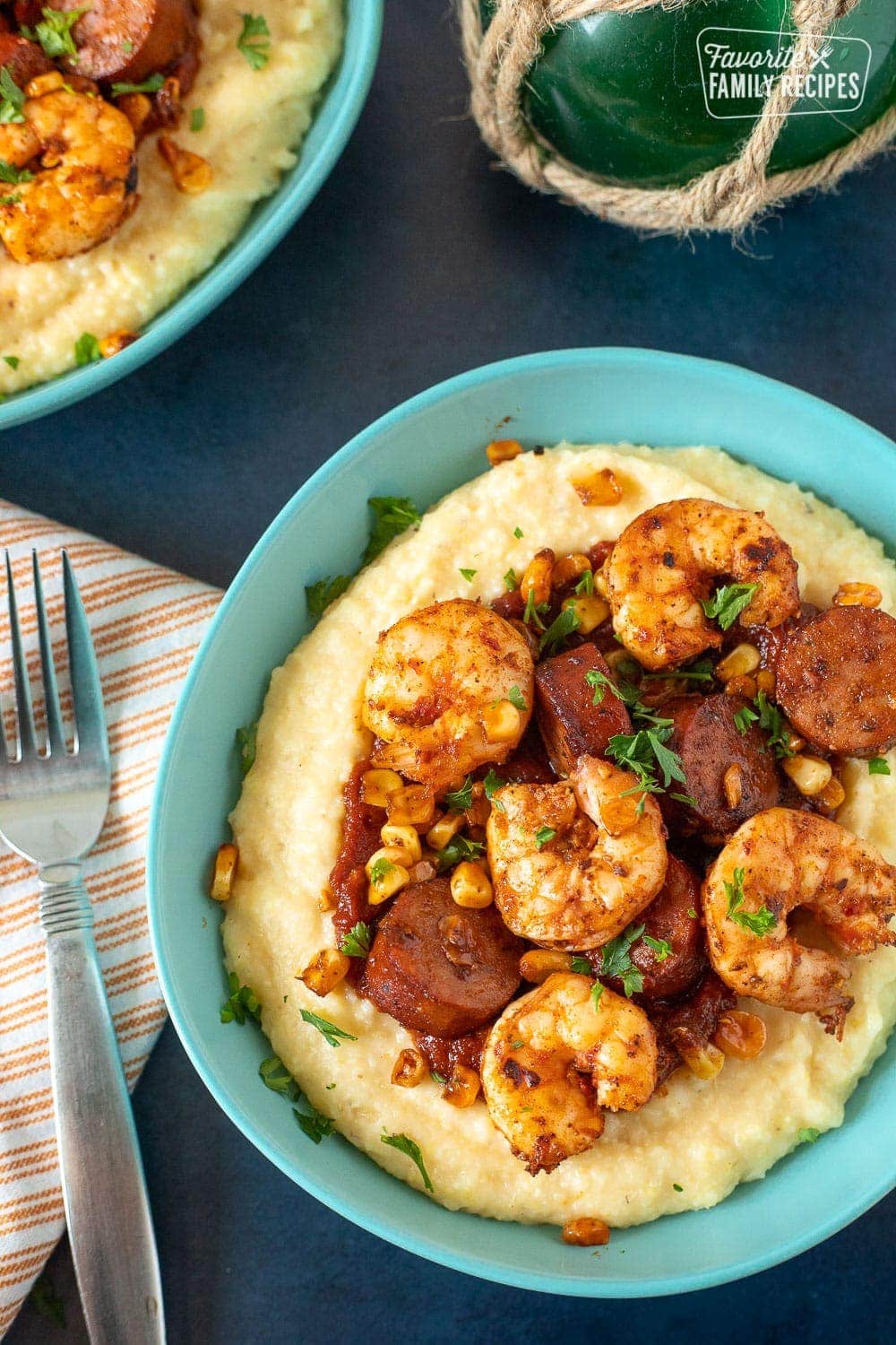 Shrimp and grits in a bowl with a napkin and fork on the side