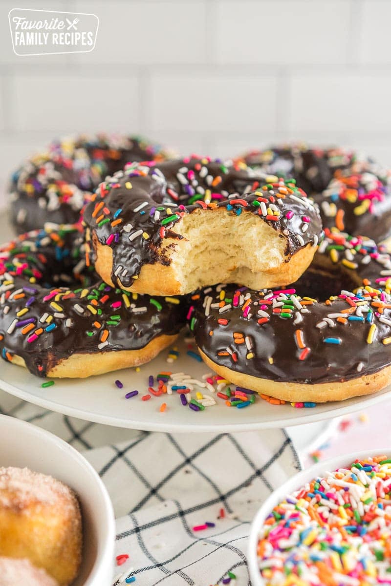 A platter of chocolate sprinkle air fryer donuts with a bite taken out of one