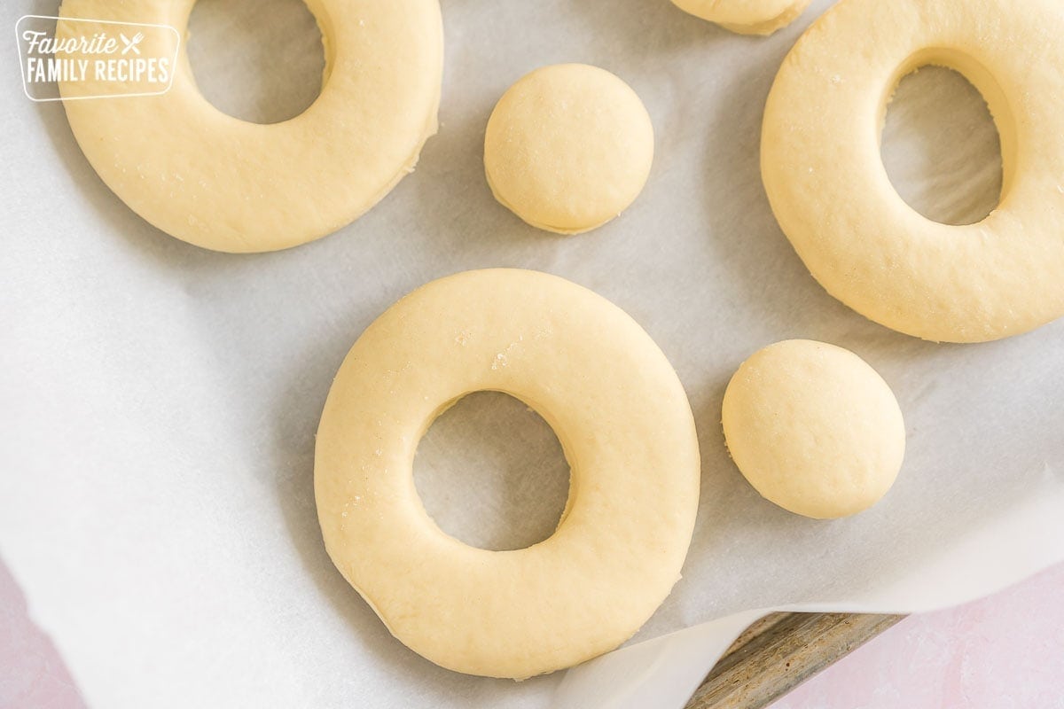 Donut dough cut into donut shapes before frying