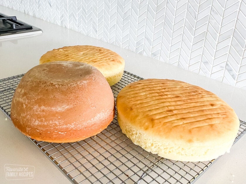 Two prepared round cakes and a bowl-shaped cake.
