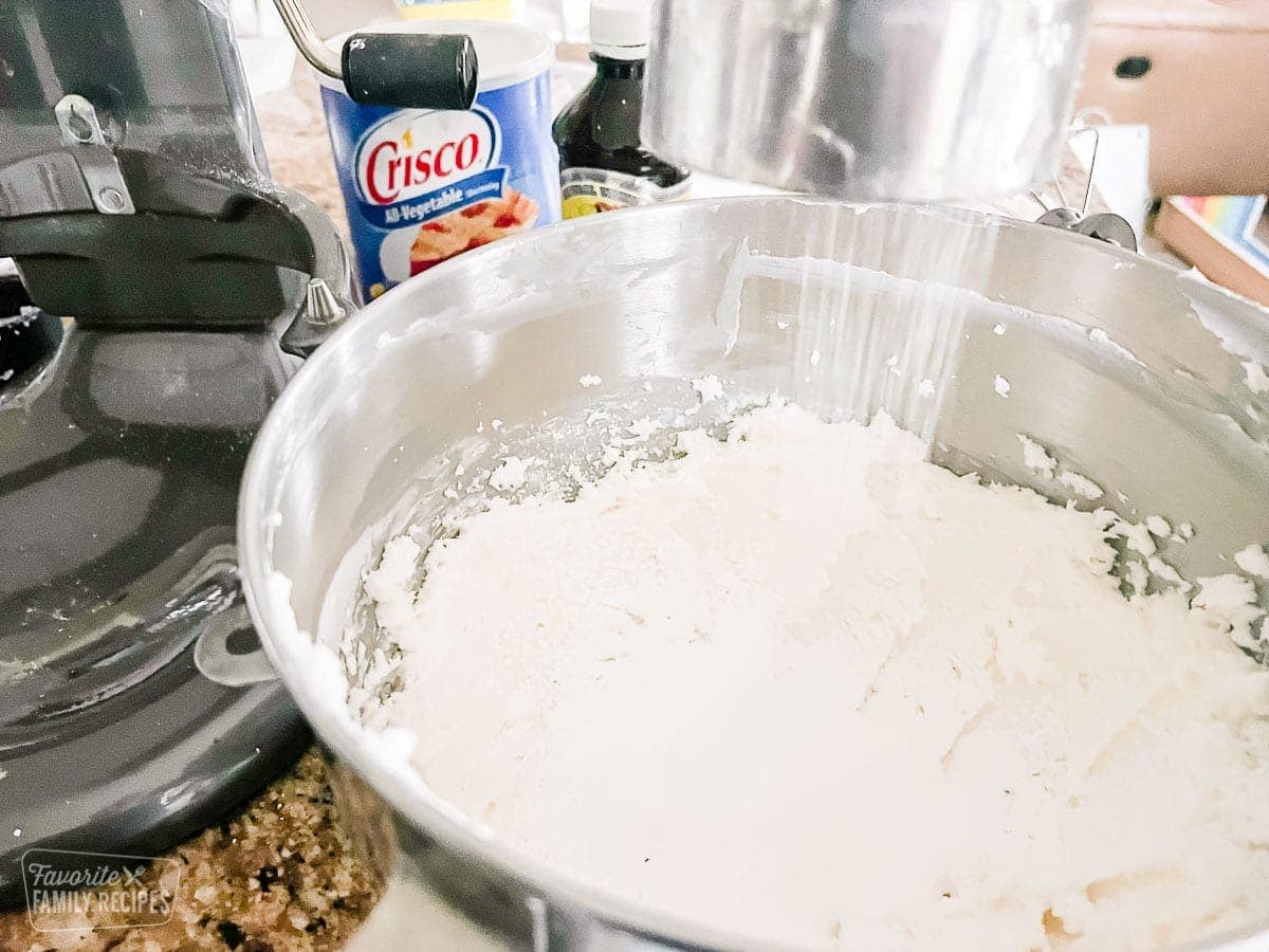 Powdered sugar being sifted into a bowl to make buttercream frosting