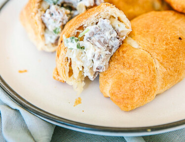 Creamy Cheesesteak Crescent rolls on a plate with one cut in half