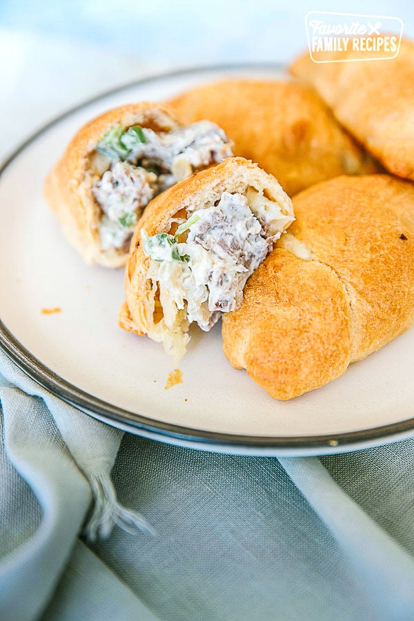 Creamy Cheesesteak Crescent rolls on a plate with one cut in half