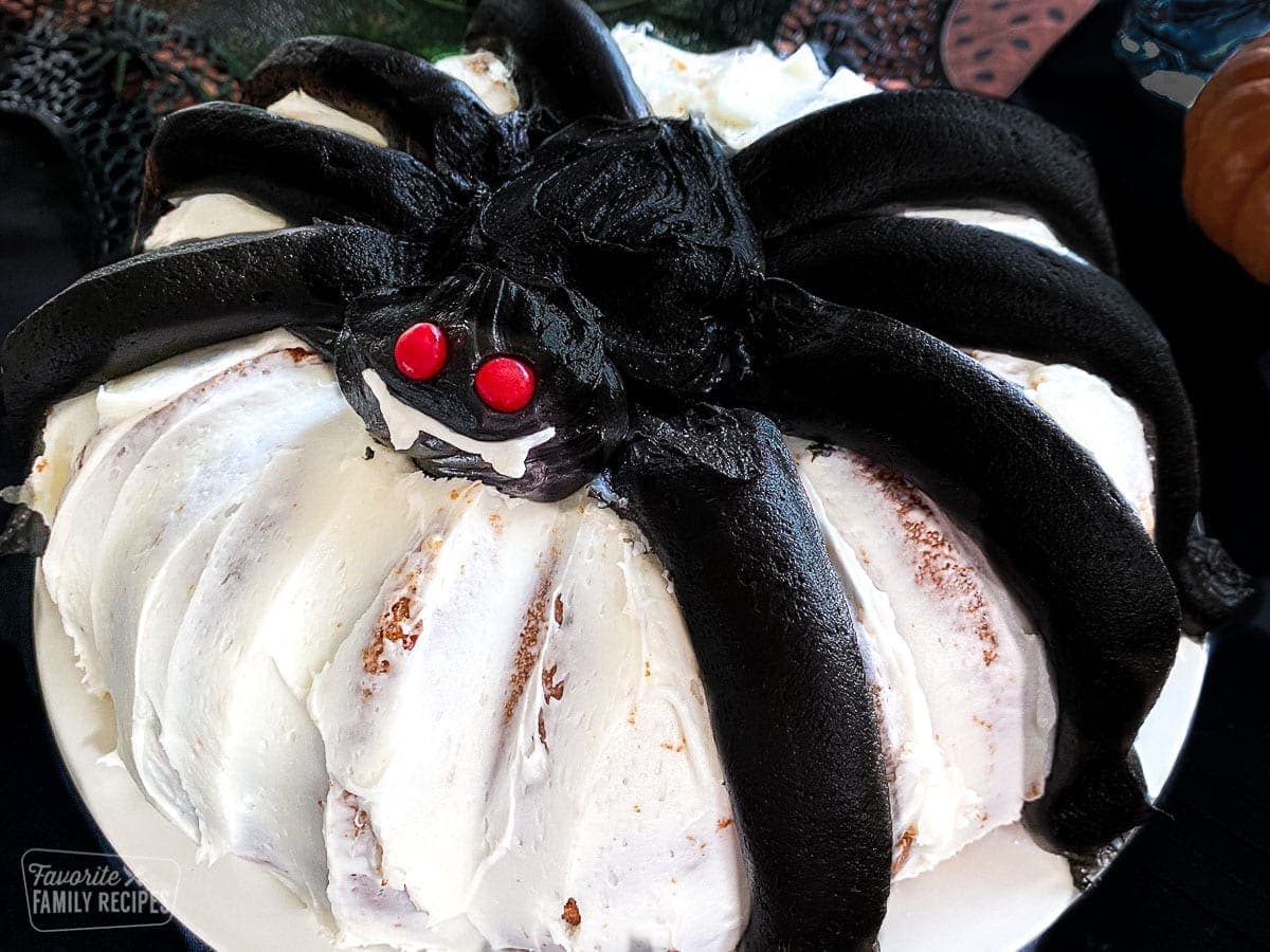 A bunt cake with a giant black frosting spider on the top.
