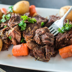 A bite of pot roast being picked up with a fork