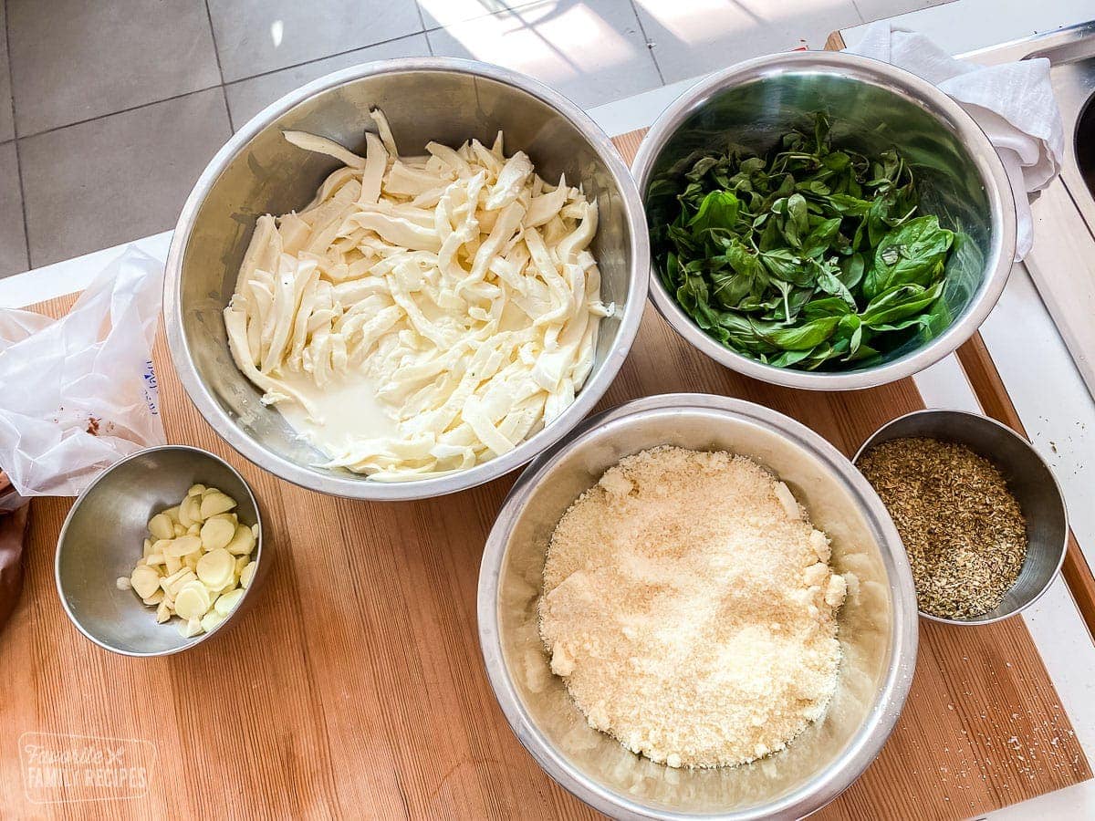 Buffalo mozzarella, basil, oregano, and garlic in bowls