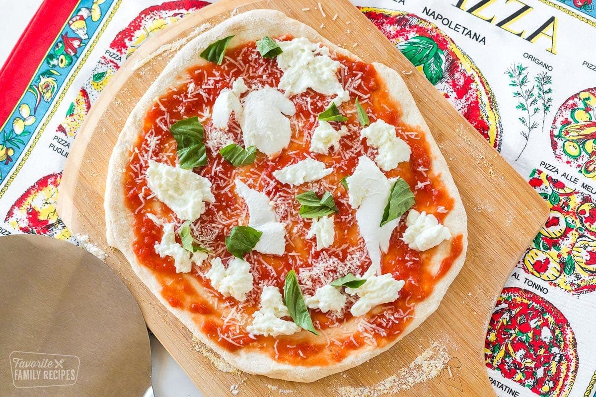 We journeyed to southern Italy to learn the art of making a true Neapolitan pizza. Here we will teach you all of the tips, tricks, and secrets to making the perfect pizza that we learned from the professional pizza chefs at the the Accadamia MedEATerranea in Naples. An uncooked pizza on a pizza peel.