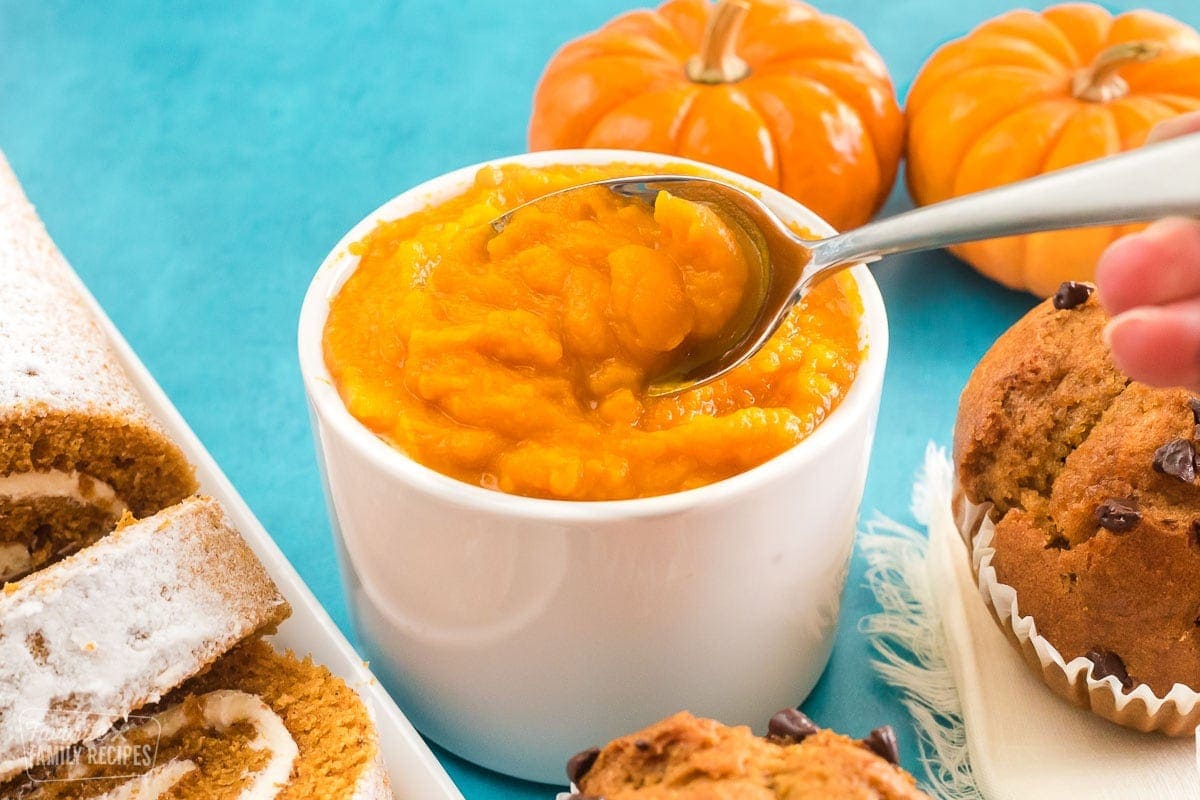 Fresh pumpkin puree in a bowl with a spoon taking a scoop