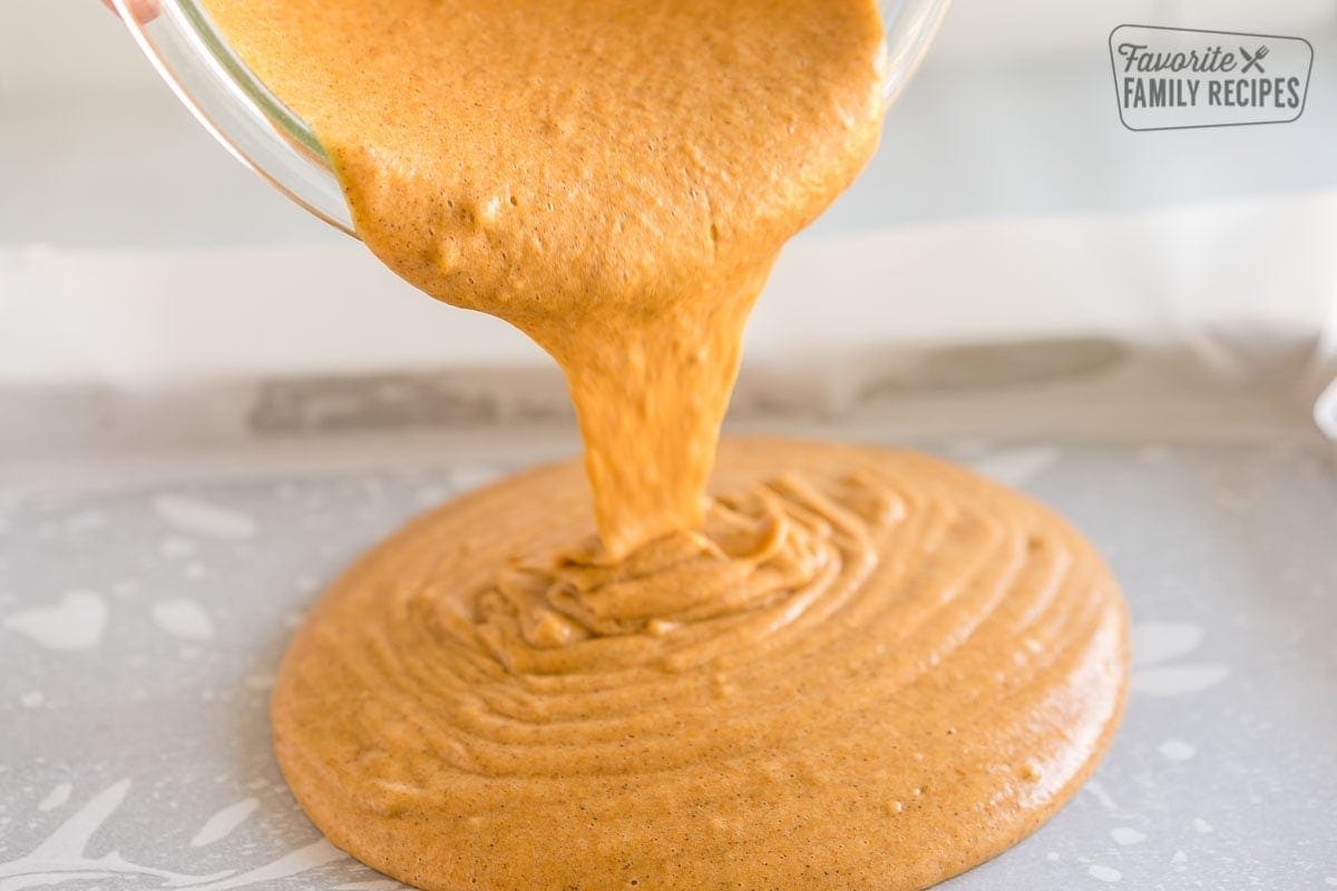 Pouring Pumpkin Roll batter onto a jelly roll pan