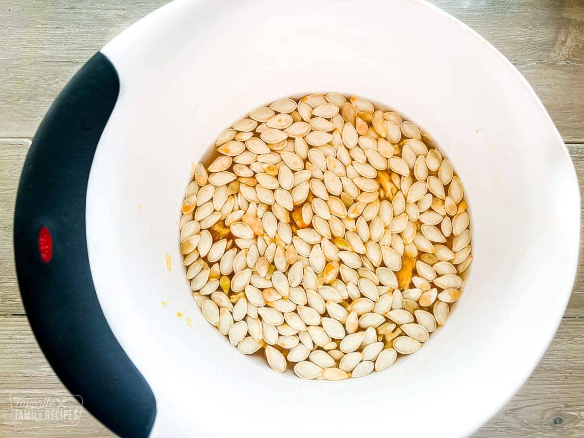 pumpkin seeds soaking in a bowl of water