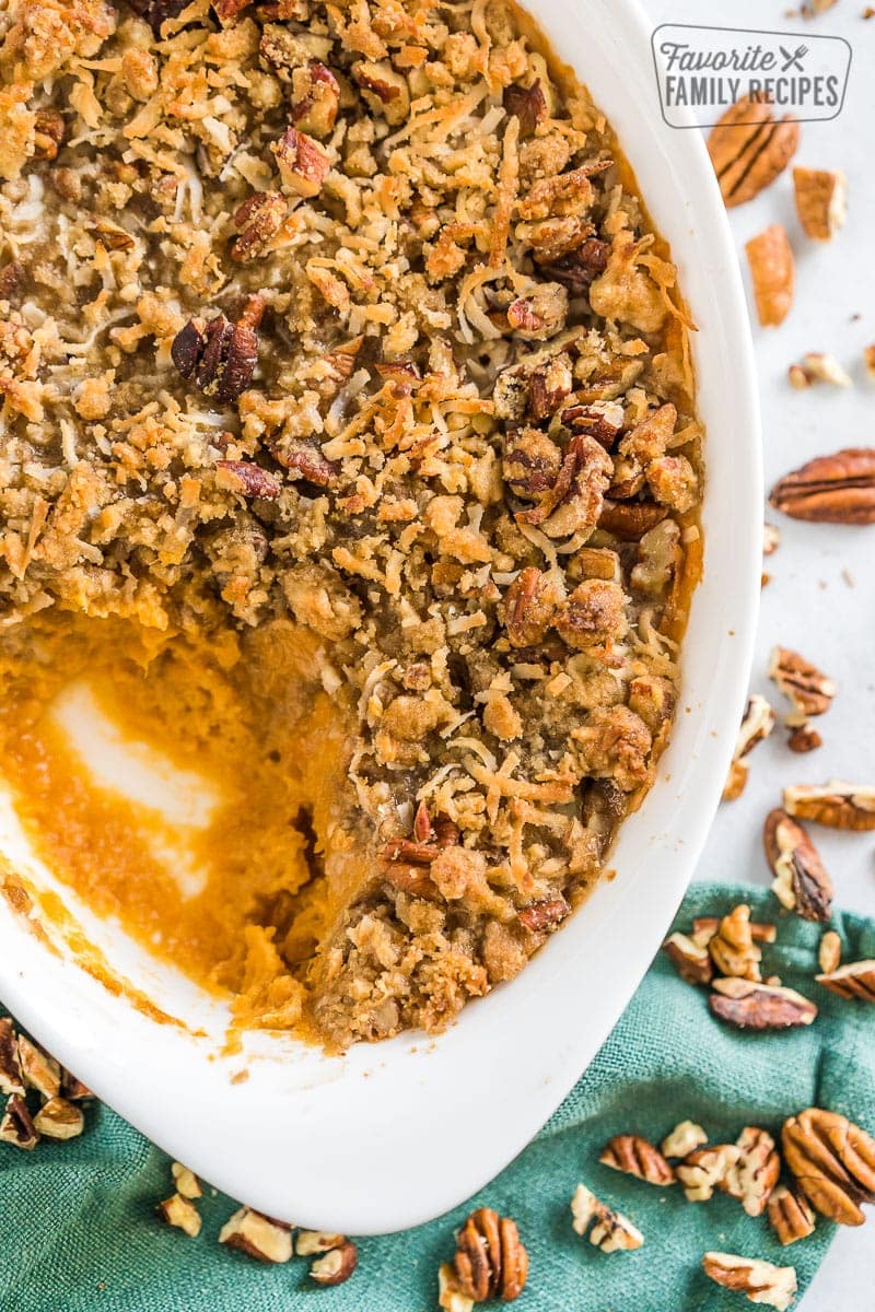 Sweet potato casserole with a scoop taken out of the side of the white dish.
