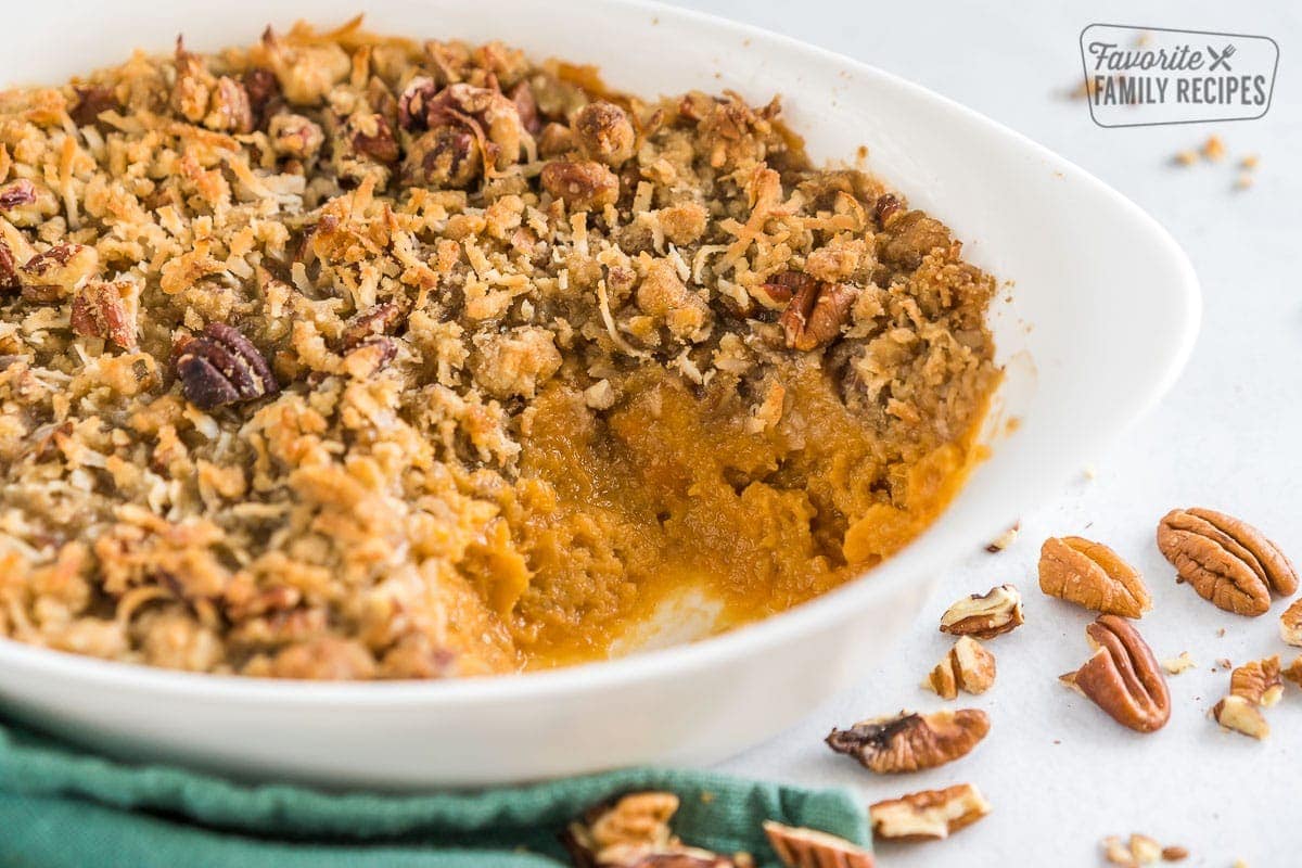 Side view of a sweet potato casserole with a scoop taken out.