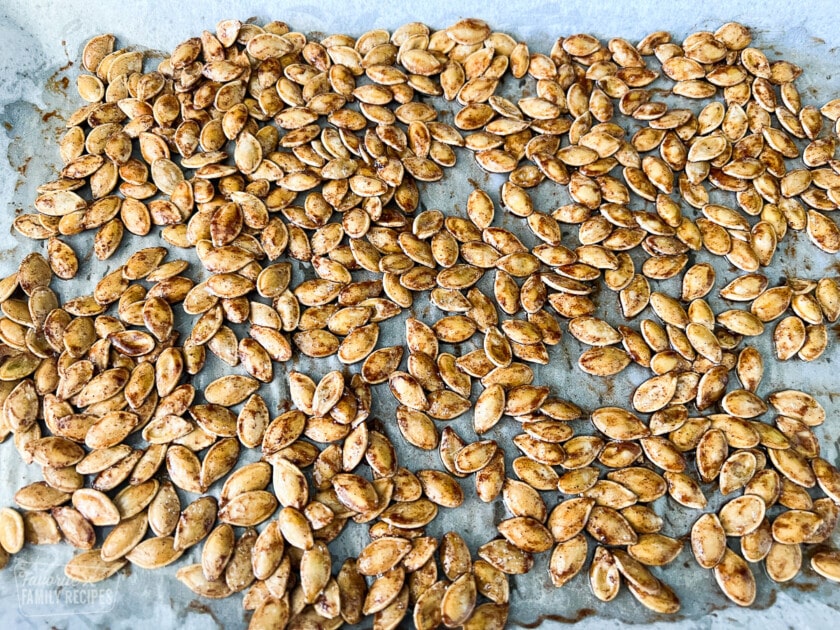 Uncooked pumpkin seeds on a baking sheet