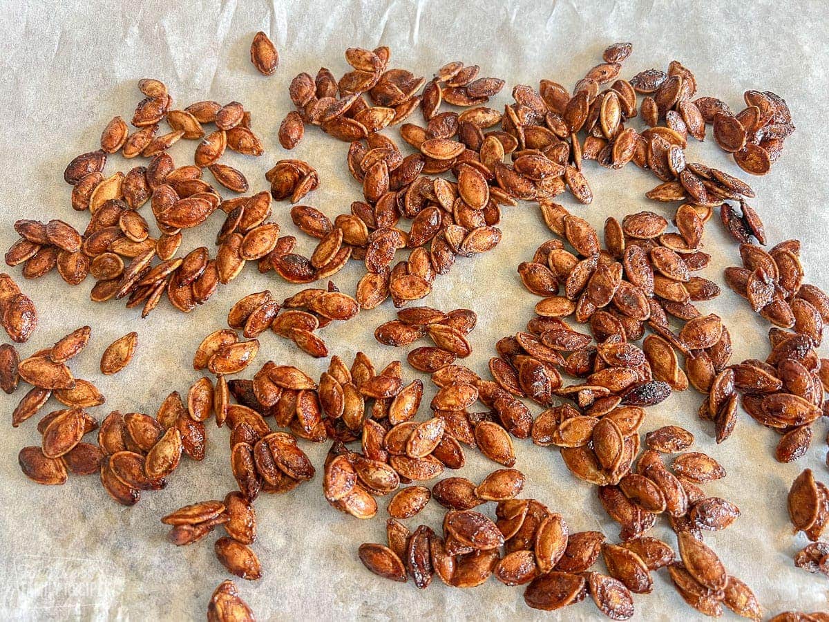 Spicy pumpkin seeds that have been roasted on parchment paper
