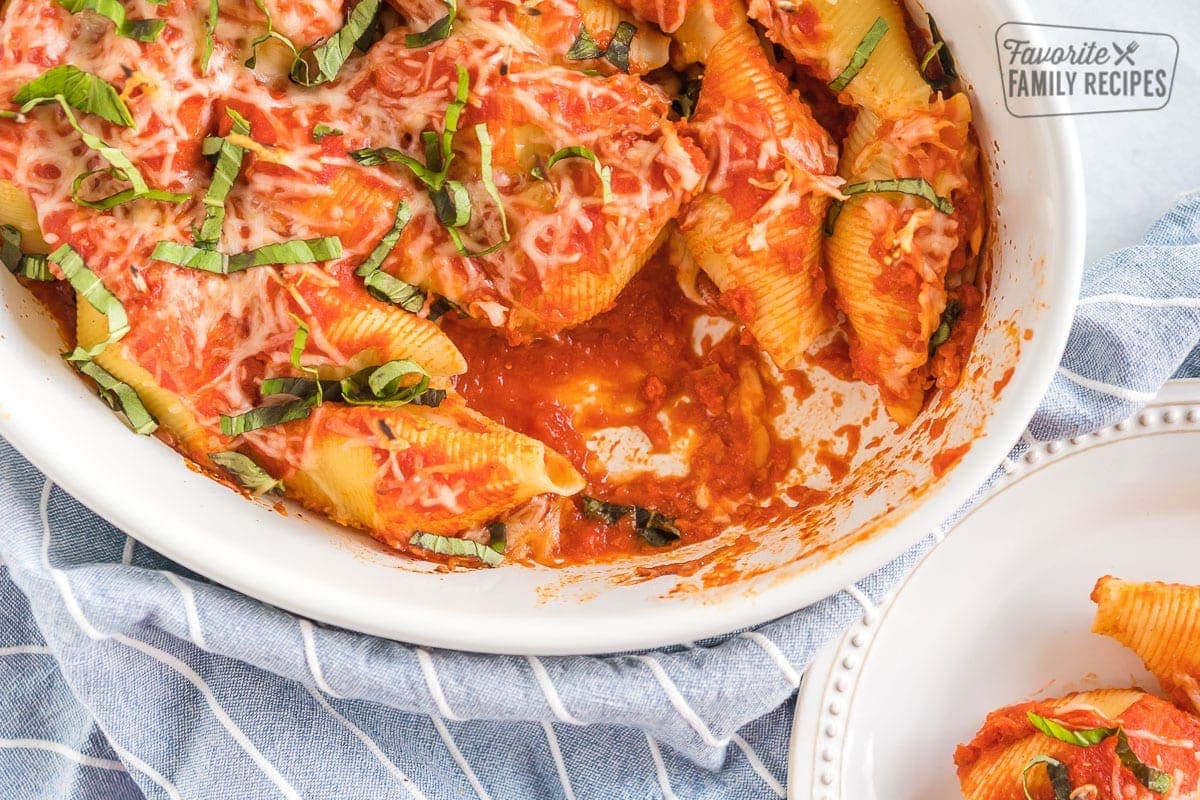 A baking dish full of Chicken Parmesan Stuffed Shells with a scoop taken out