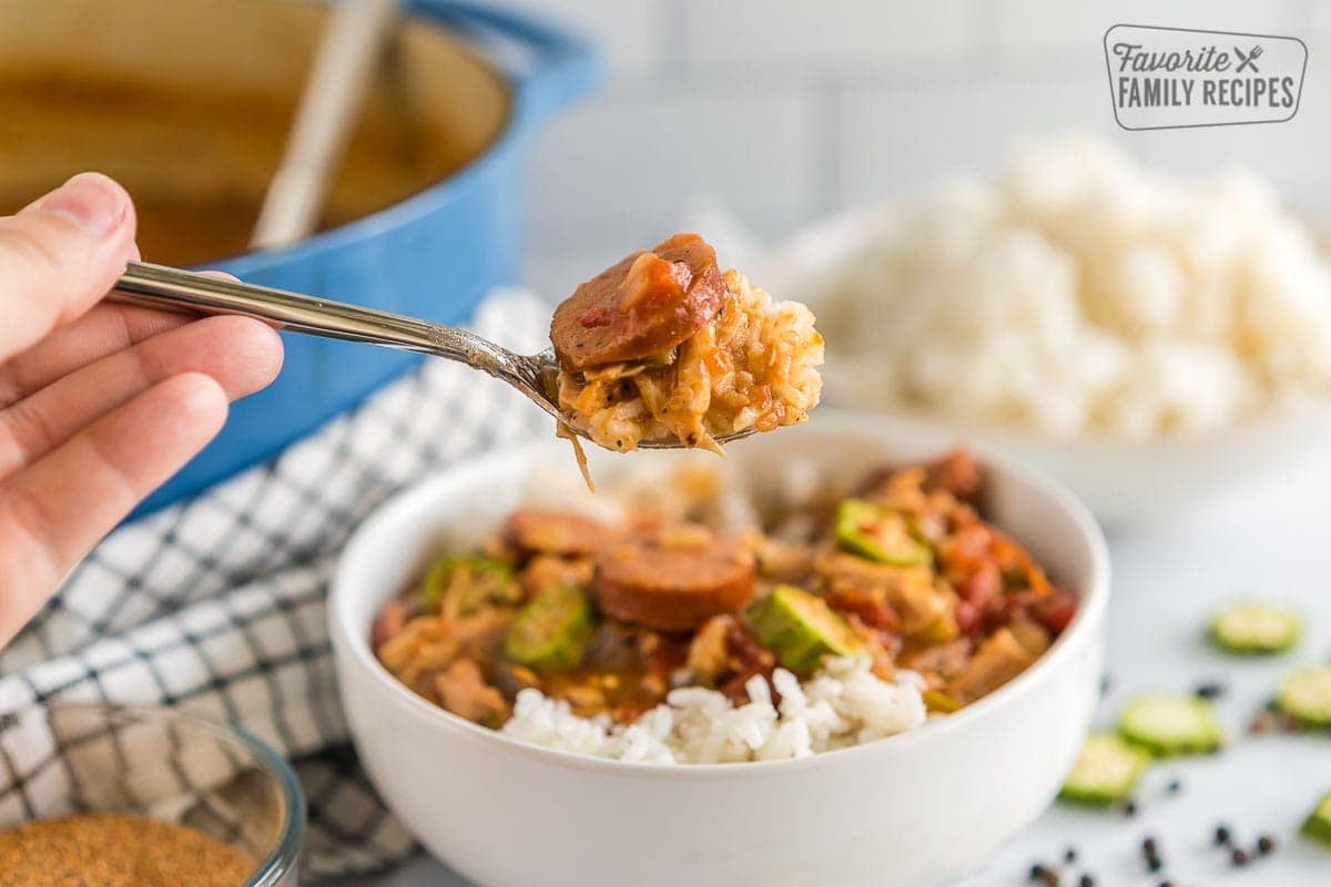 This chicken and sausage gumbo is a rich and flavorful version of the classic Louisiana stew. Filled with thick chunks of chicken and sausage, diced bell peppers, celery, and sliced onions, all encompassed in tomatoes and savory cajun seasoning. It is the perfect combination! A bite of chicken and sausage gumbo on a spoon.