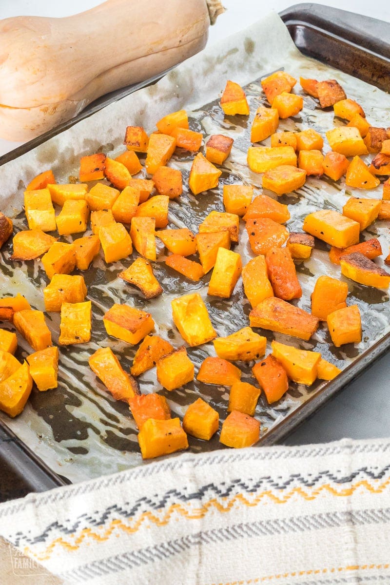 Cubed roasted butternut squash on a roasting sheet