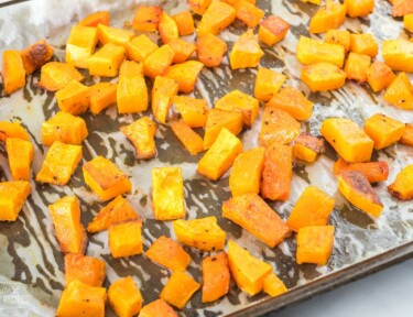 Close up view of butternut squash on a baking sheet