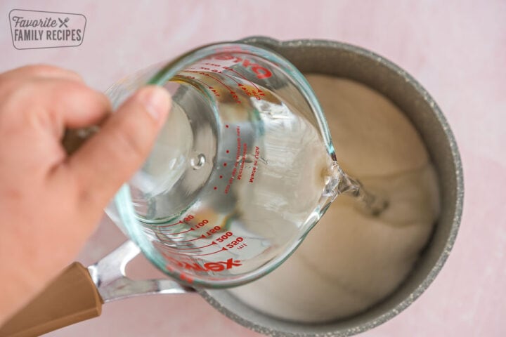 Water being poured into a pot with sugar