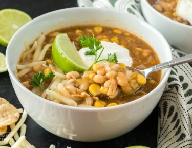 A close up of a bowl of chili made with chicken and white beans