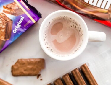 Three packages of Tim Tams and a mug of hot chocolate