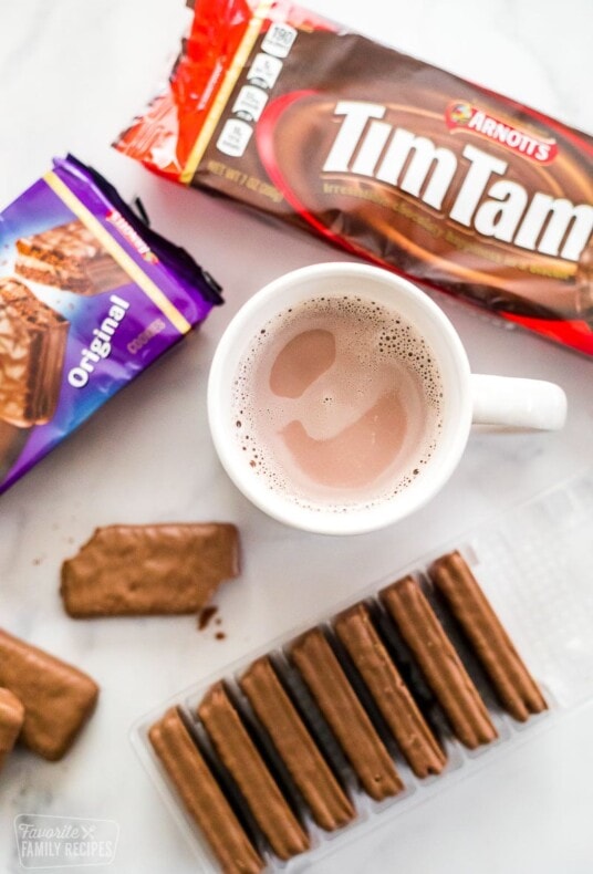 Three packages of Tim Tams and a mug of hot chocolate