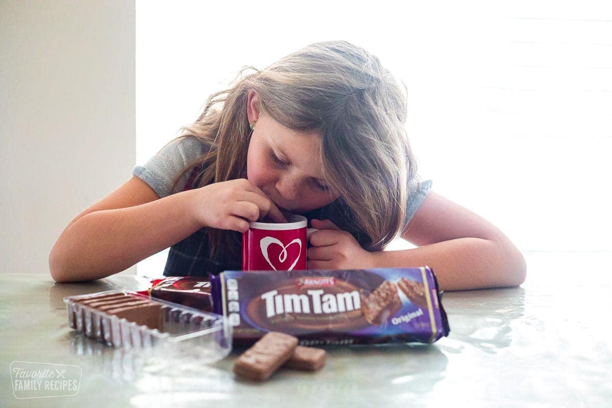 A girl doing the Tim Tam slam