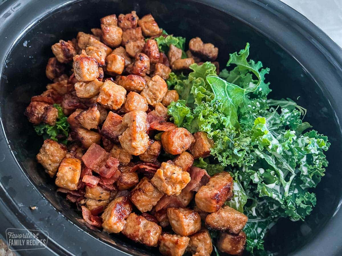 Cooked sausage, bacon and kale in a Crock Pot